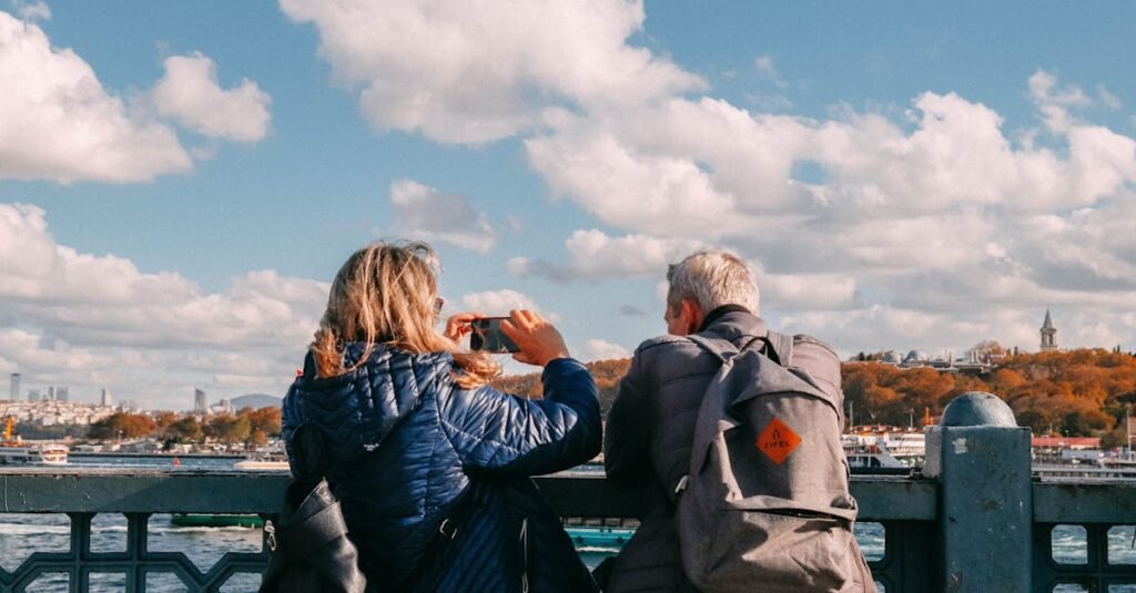 Two adults enjoying the view from a bridge, capturing scenic river sights under a vibrant sky.