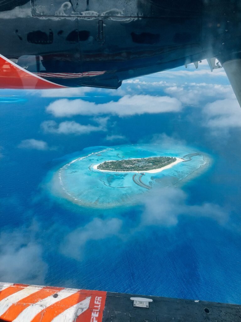 A breathtaking aerial shot capturing a tropical island in the Maldives surrounded by turquoise waters.